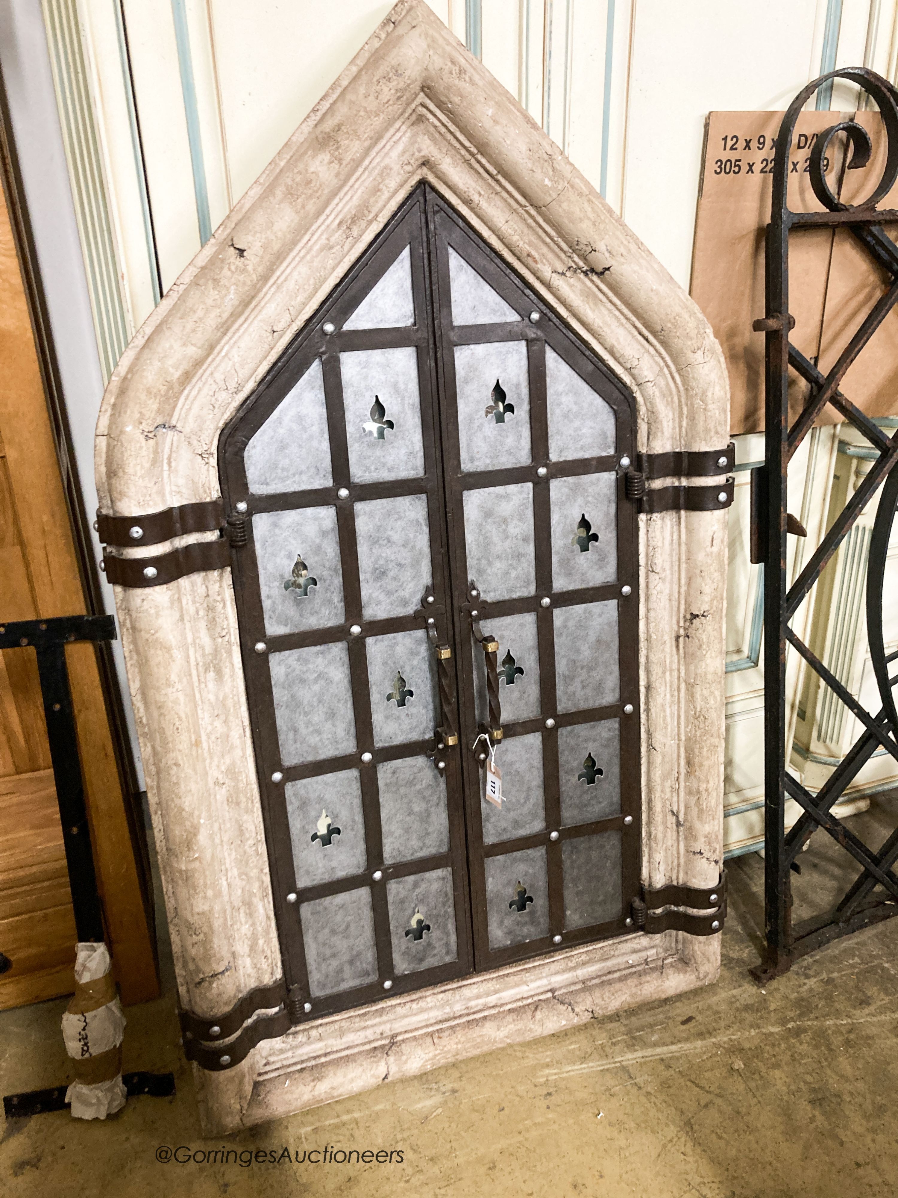 A medieval style simulated stone and wrought iron wall mirror, width 92cm, height 156cm